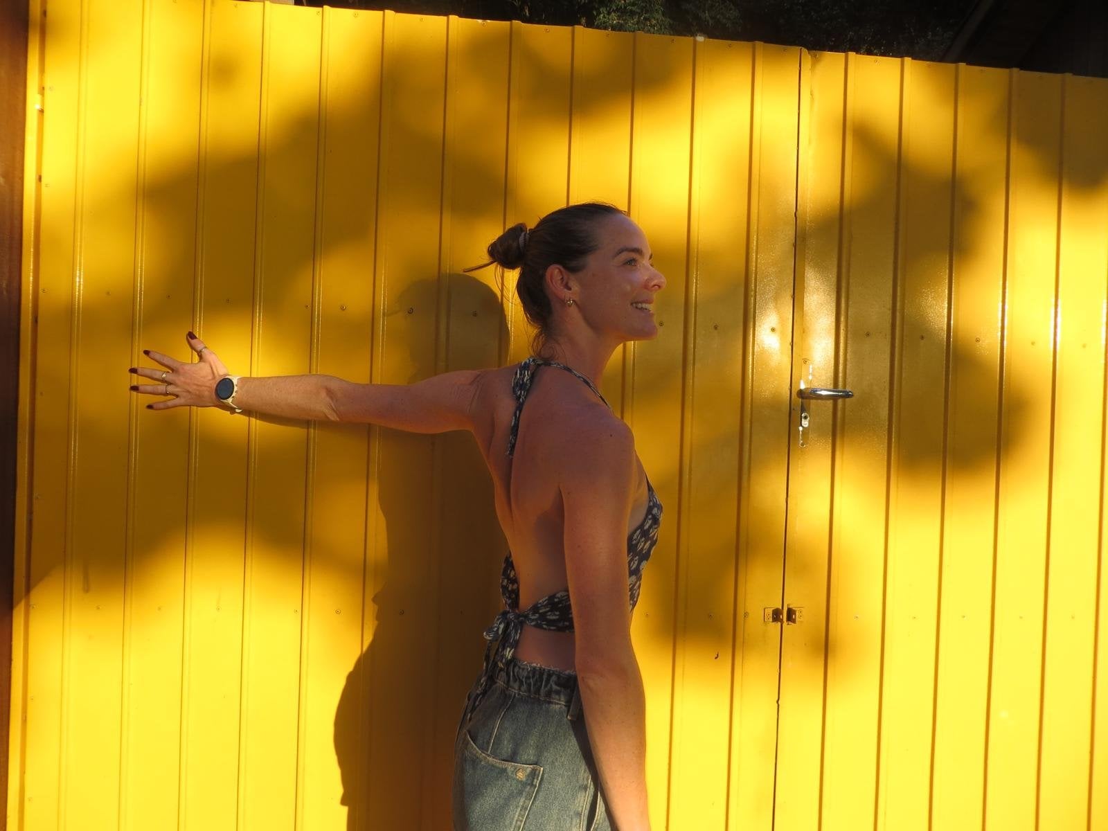 Zael outdoors by a yellow wall