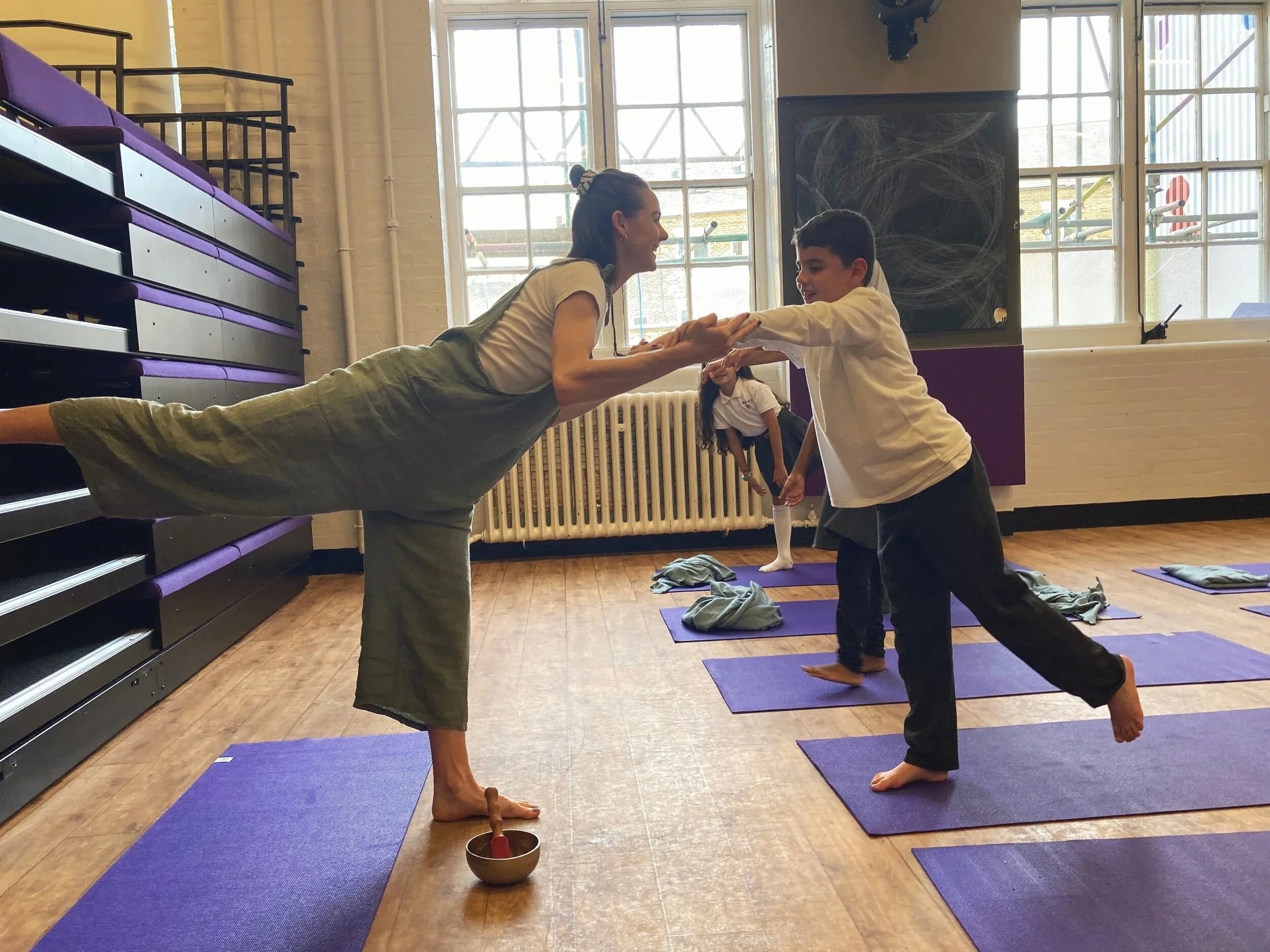 Zael guiding a child through a balancing pose