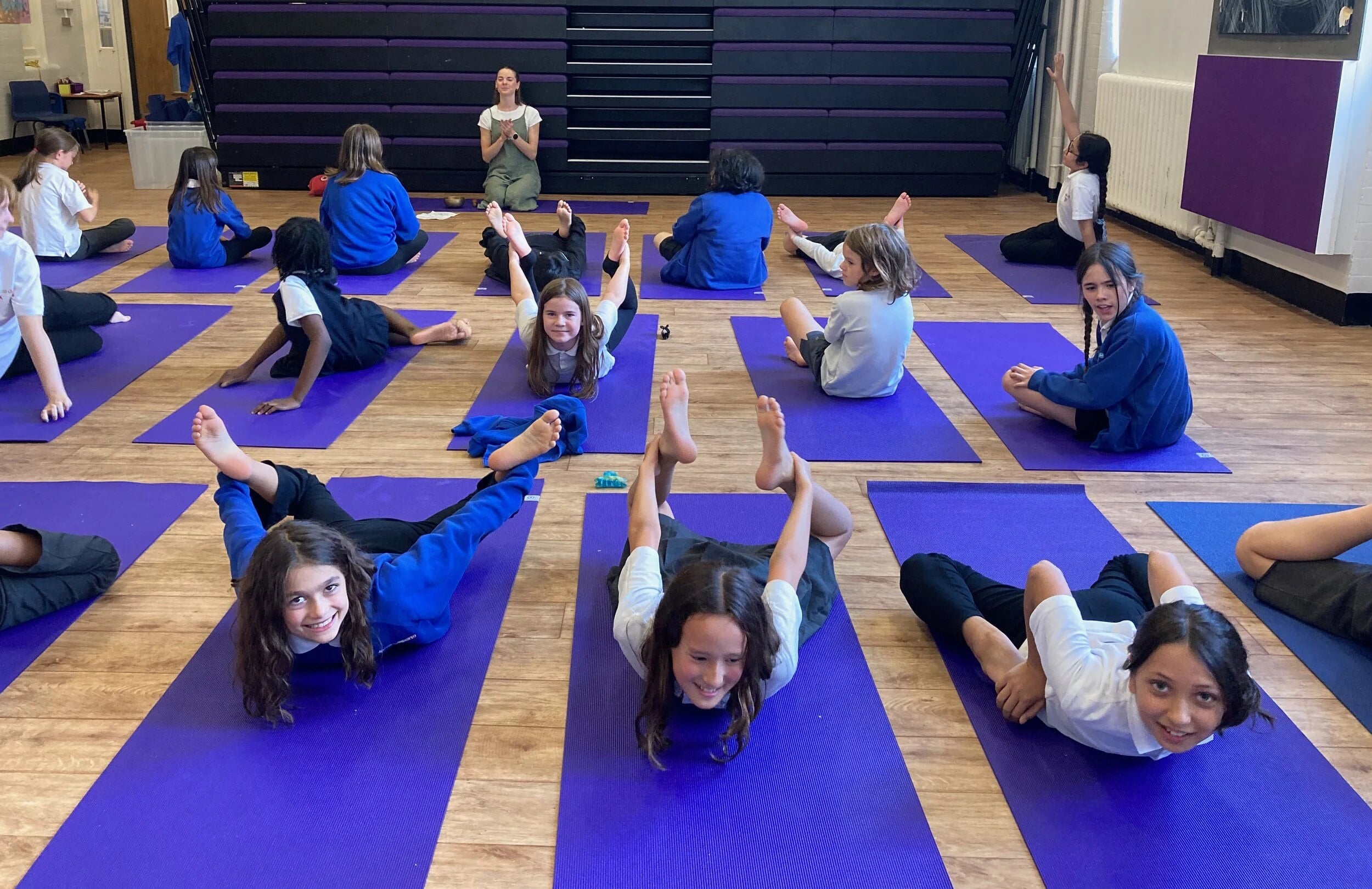 A hall full of children practising yoga