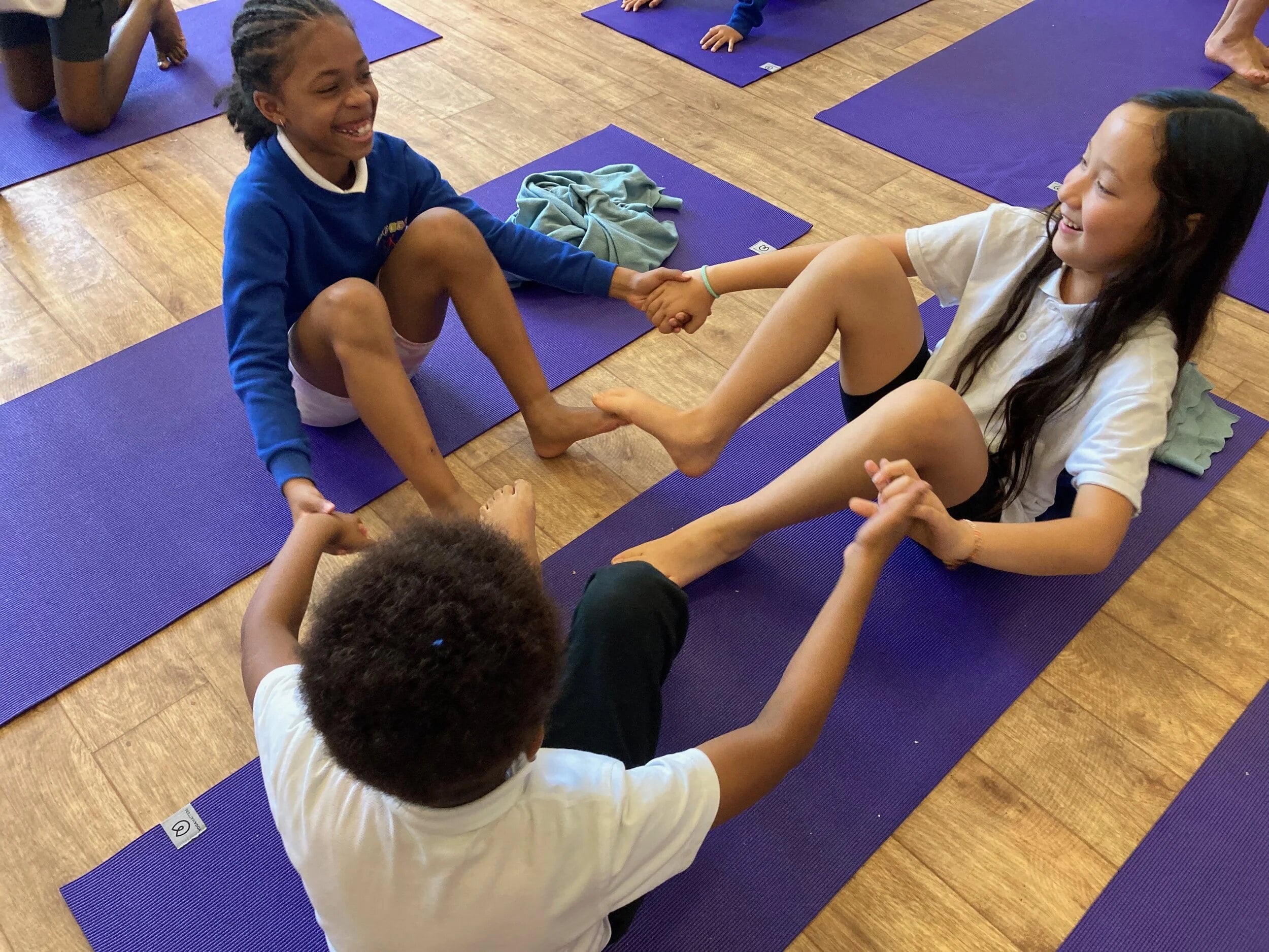 Children laughing together on yoga mats