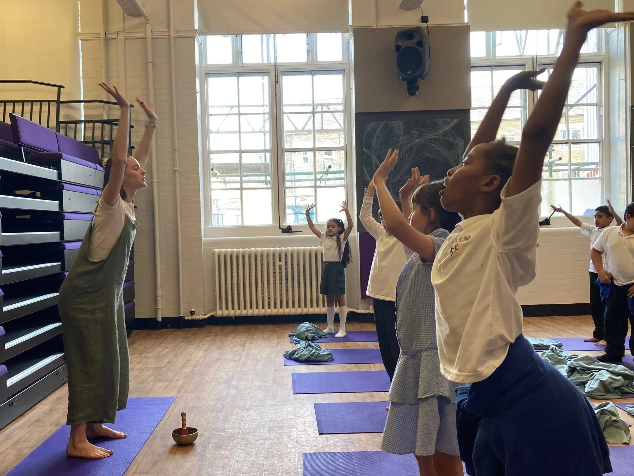 Children reaching up in a school hall